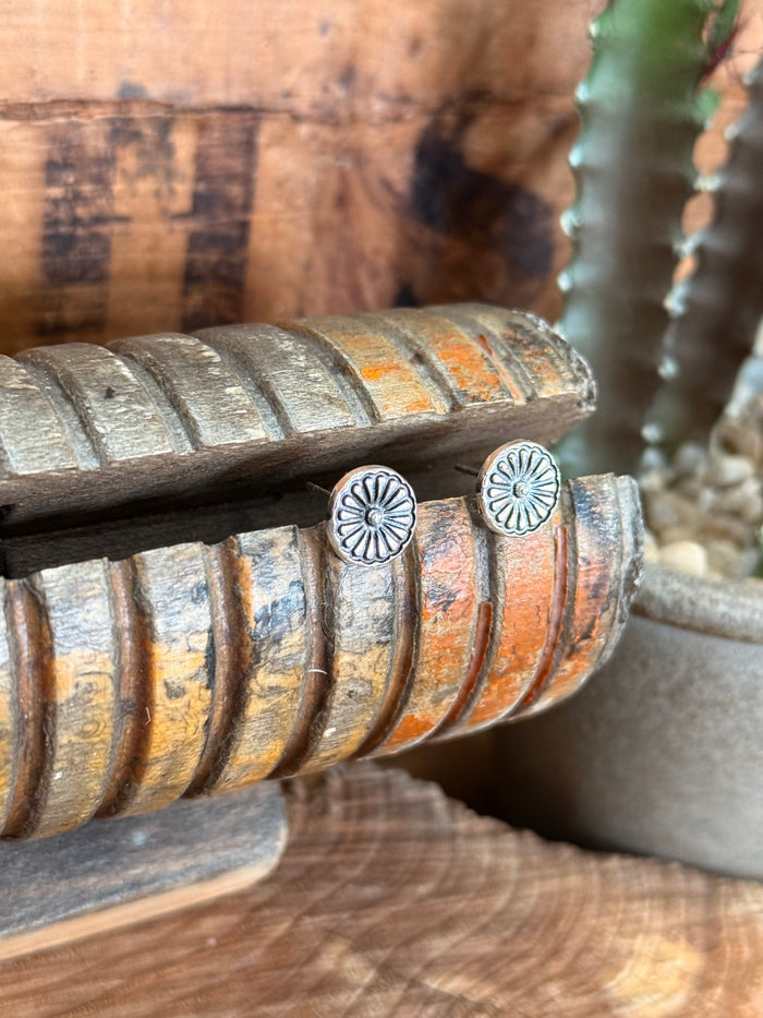 Silver concho stud earrings showing two round embossed discs with floral design