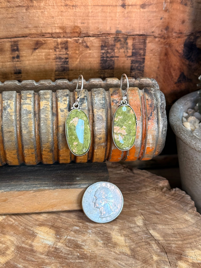 Silver-plated fishhook earrings with green oval natural stone cabochons, with coin for scale