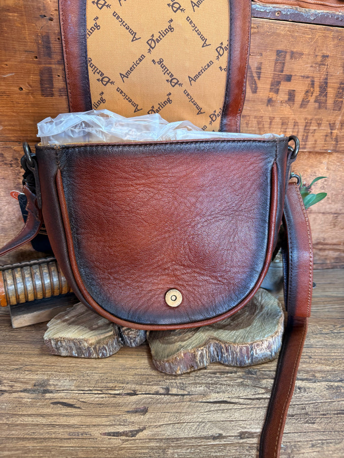 Brown leather-look flap crossbody bag with top snap, metal grommet, and crossbody strap