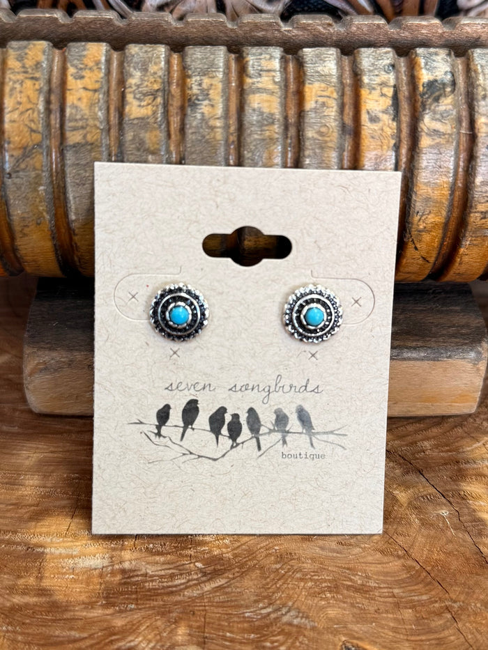 Round silver concho stud earrings with bright turquoise cabochons on display card