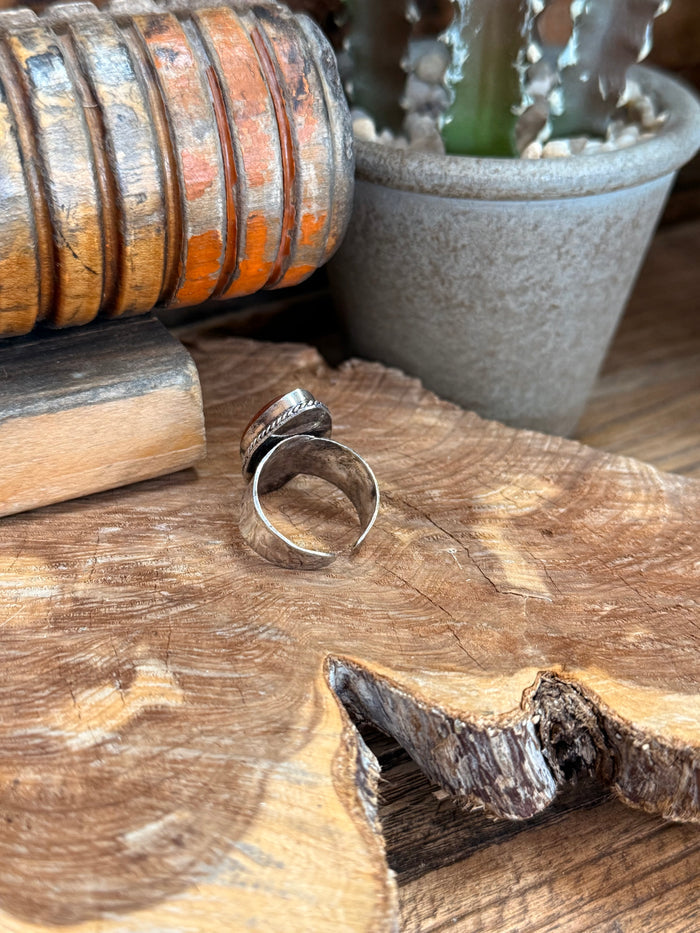 Adjustable silver-tone ring, rear view of open band and oval red stone setting