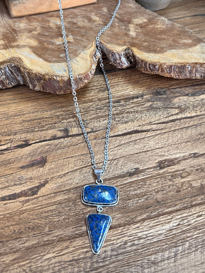 Silver lariat necklace featuring layered blue stone oval and teardrop charms