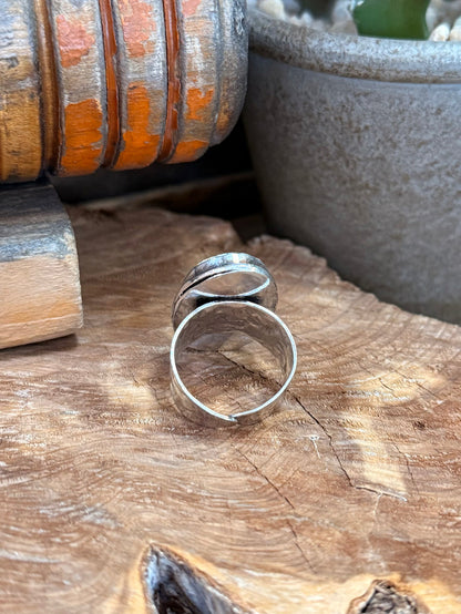 Adjustable silver-plated ring band with open oval frame, stone not shown from this angle