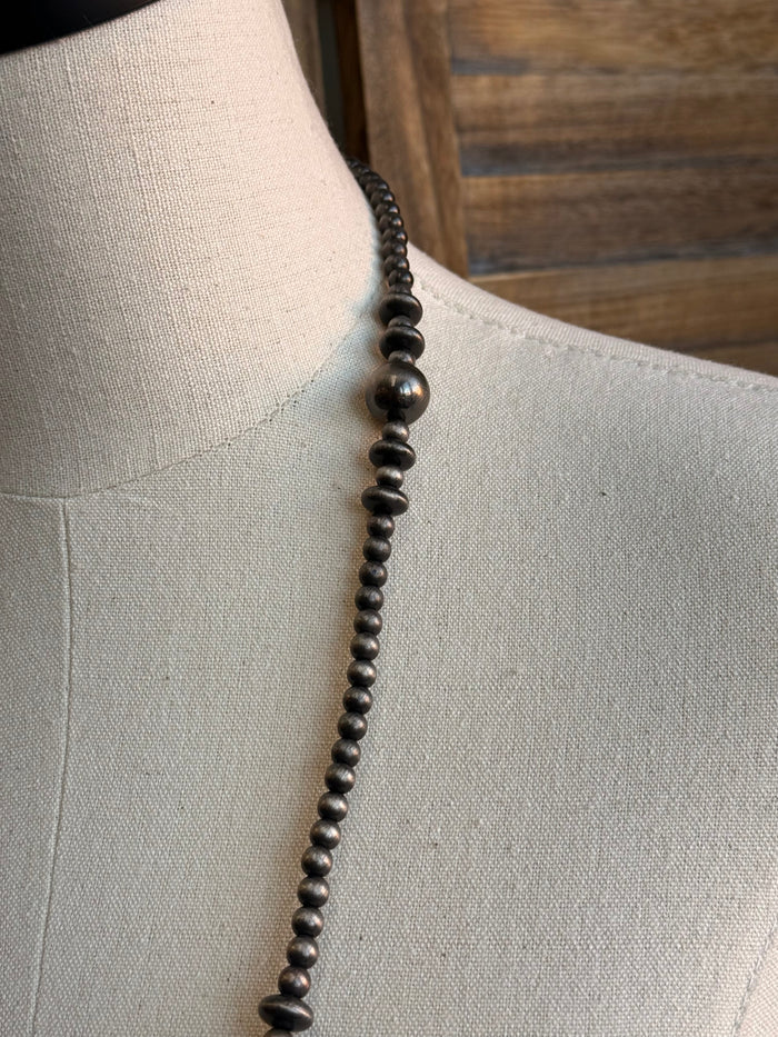 Mixed silver pearl bead necklace detail, close-up of round bead strand
