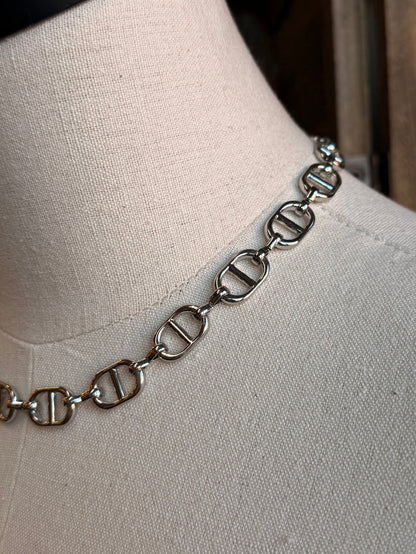 Close-up silver bottle-cap link necklace chain detail