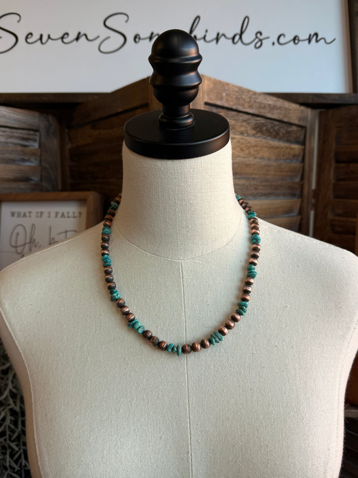 Beaded turquoise and copper bead necklace with round beads on a mannequin bust