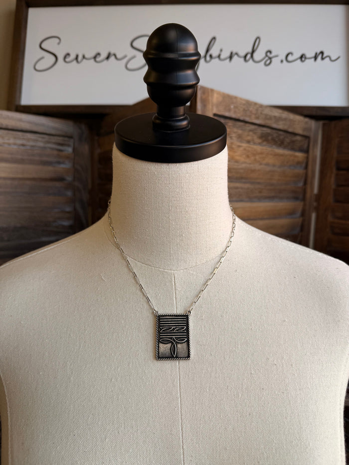 Silver-tone necklace with rectangular stitched boot pendant on thin chain