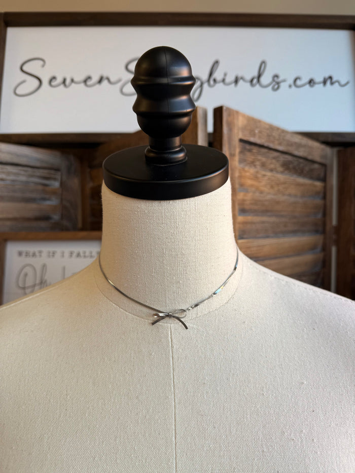 Silver bow chain choker, slender links with ribbon-style bow at neckline