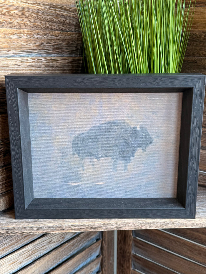 Framed buffalo artwork in a dust storm, dark gray frame with green grass on top