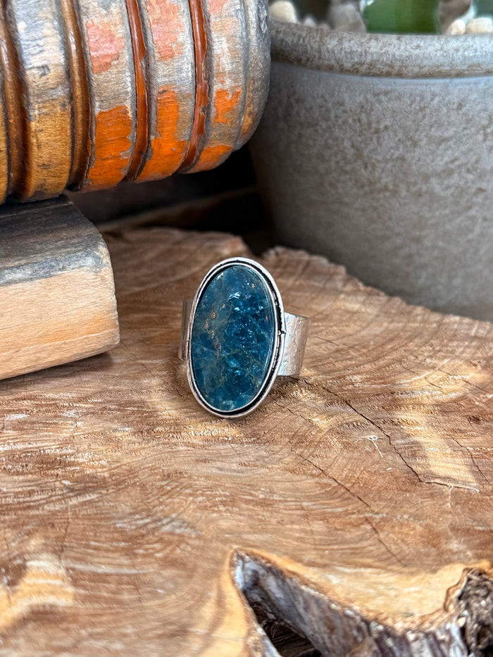 Adjustable silver-tone ring with oval blue apatite-style stone bezel setting