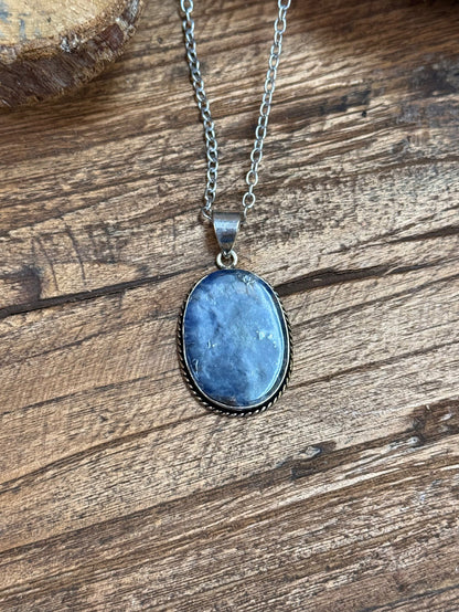 Oval blue sodalite pendant necklace with silver chain and dark bezel frame