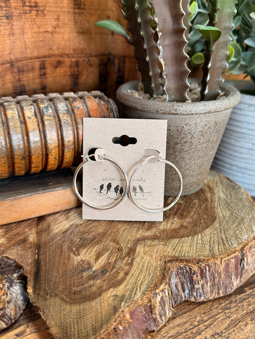 Sterling silver hoop earrings with small black bead accent at top.