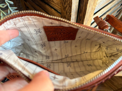 Inside view of rusty brown mini wristlet bag lining with interior label and stitched seams