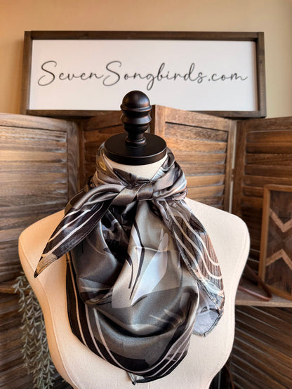 Wild rag scarf in gray and black with horse collage print, knotted on mannequin