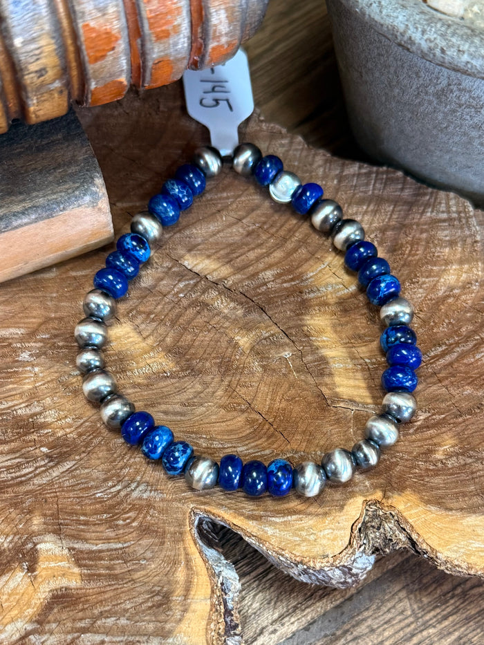 Close-up of dark blue jasper and silver beaded stretchy bracelet with round spacers