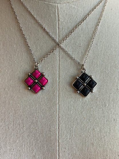 Diamond four-stone pendant set: pink and black square clusters on silver chains