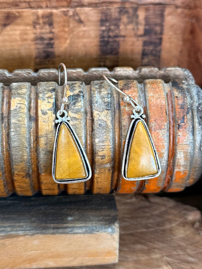 Pair of silver fishhook earrings with teardrop yellow stone drops in metal bezels