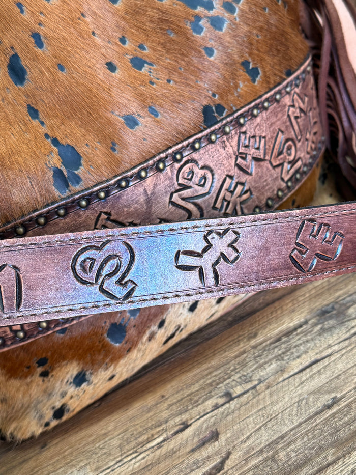 Fringed cowhide crossbody purse detail: embossed decorative band with metal studs