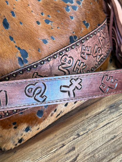 Fringed cowhide crossbody purse detail: embossed decorative band with metal studs