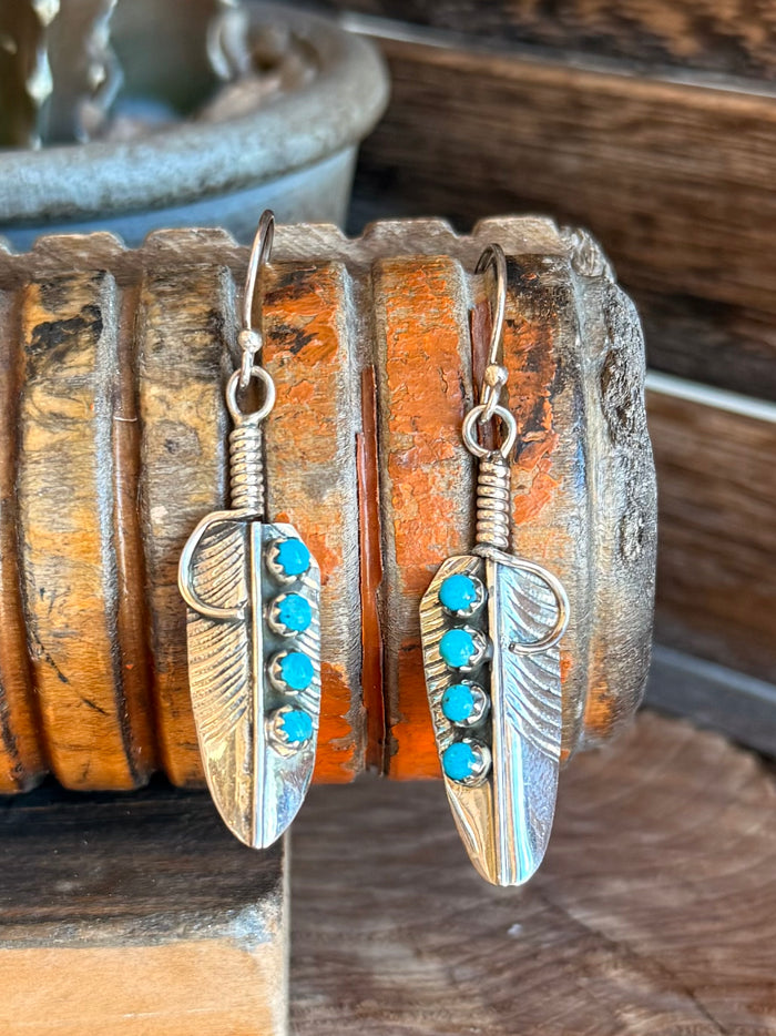 Silver dangle earrings with three turquoise beads on engraved leaf feather charms