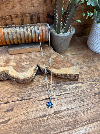 Lapis-blue round pendant necklace with silver chain and small halo accents