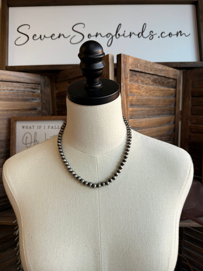 Triple pearl stack necklace with silver-tone beaded strands, layered look on mannequin