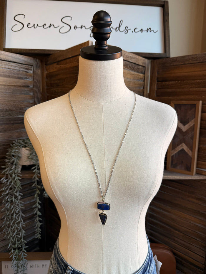 Silver-plated lariat necklace on mannequin with blue rectangular and teardrop charms