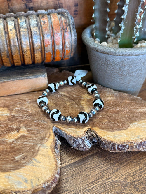 Stretch bracelet with black, white, and silver bead accents on a wrist