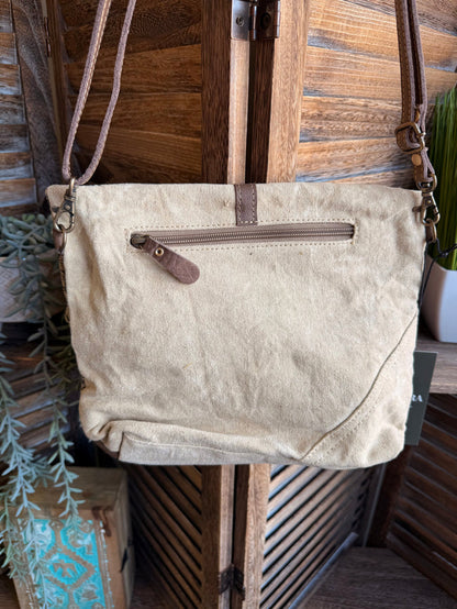 Canvas crossbody bag with natural fabric, front zipper pocket, and brown leather strap