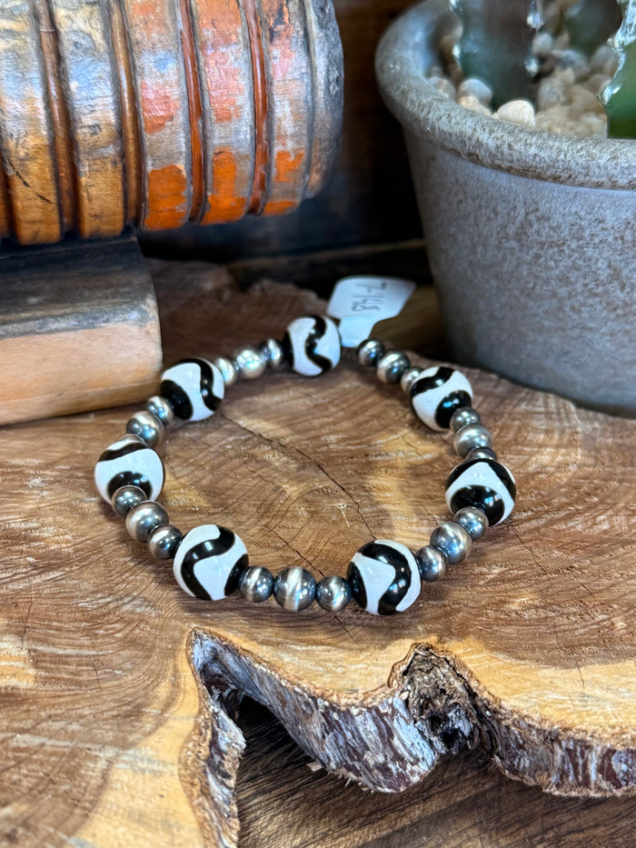 Beaded stretch bracelet with black and white oval beads and silver spacer beads