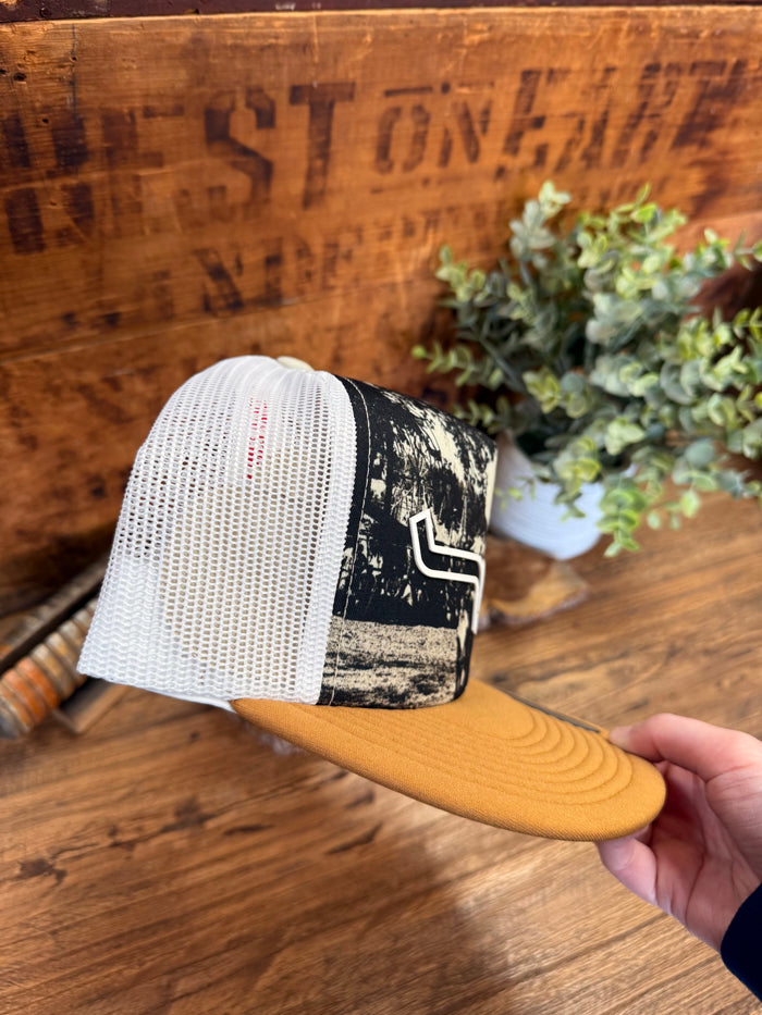 White mesh trucker cap back with black-and-white graphic front and tan brim