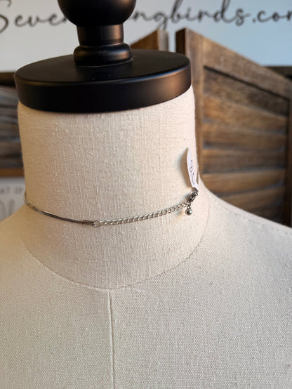 Silver chain choker with bow accent and tiny bead detail near side