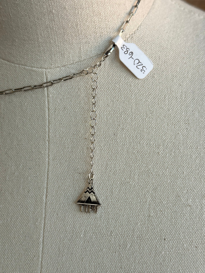 Silver drop necklace with dangling checkered bunny charm and stamped metal tag