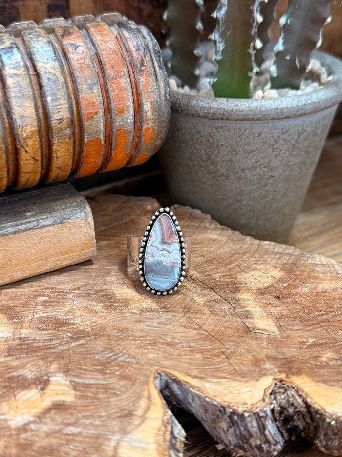 Adjustable silver-tone ring with blue-gray teardrop stone and beaded edge