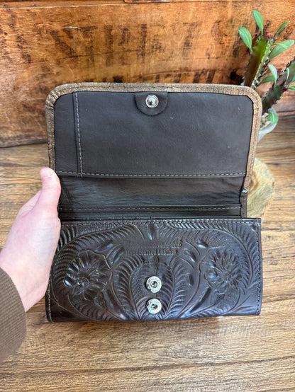 Open dark leather wallet with snap closure and embossed floral front panel
