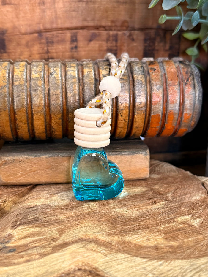 Heart-shaped scent diffuser bottle with blue glass base and white ridged stopper