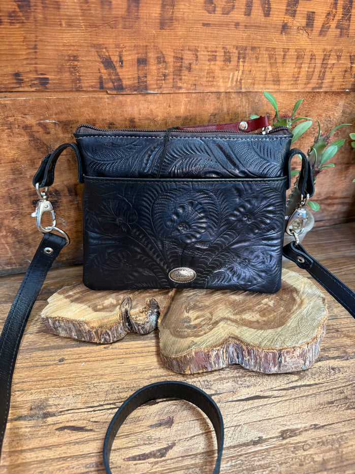 Navy leather crossbody purse with embossed floral design and adjustable strap
