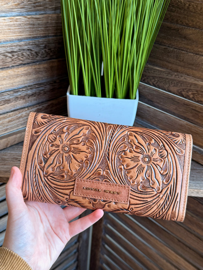 Brown tooled leather flap wallet with floral embossing and centered flap pocket, closed.