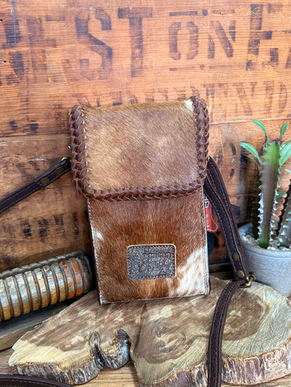 Brown cowhide crossbody pouch bag with braided trim, flap top, and square logo patch