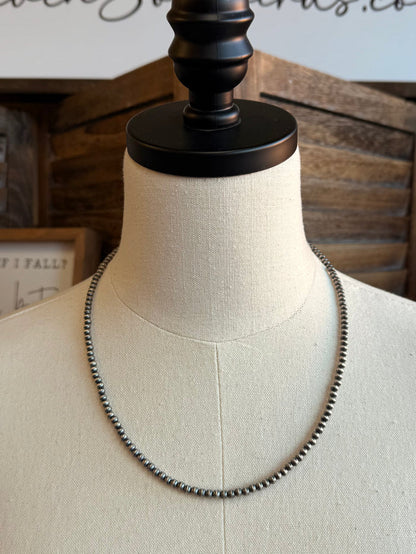 Sterling silver 20-inch beaded chain necklace, centered on mannequin neckline