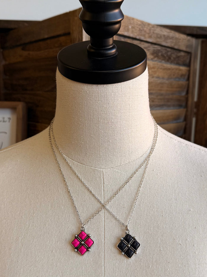 Diamond four-stone necklace featuring pink and black square pendants with silver chains