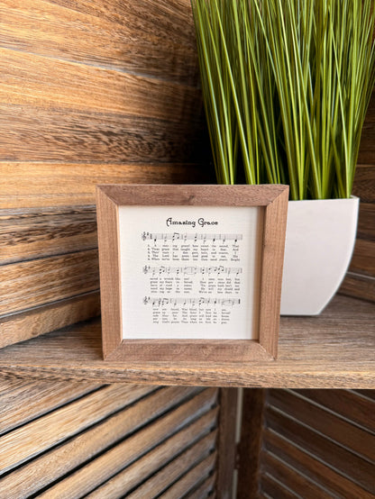 Framed sheet music artwork with wood frame and musical notes on cream paper