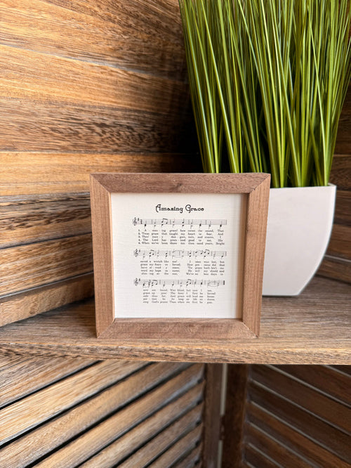 Framed sheet music artwork with wood frame and musical notes on cream paper
