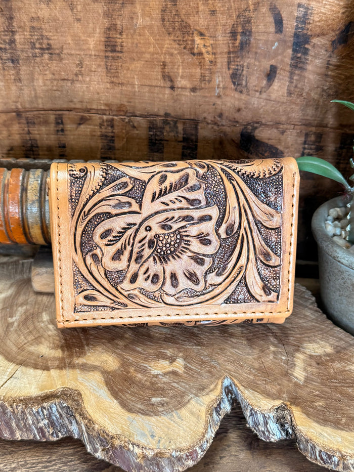 Tan cowhide trifold wallet with detailed floral tooled panel and stitched edges