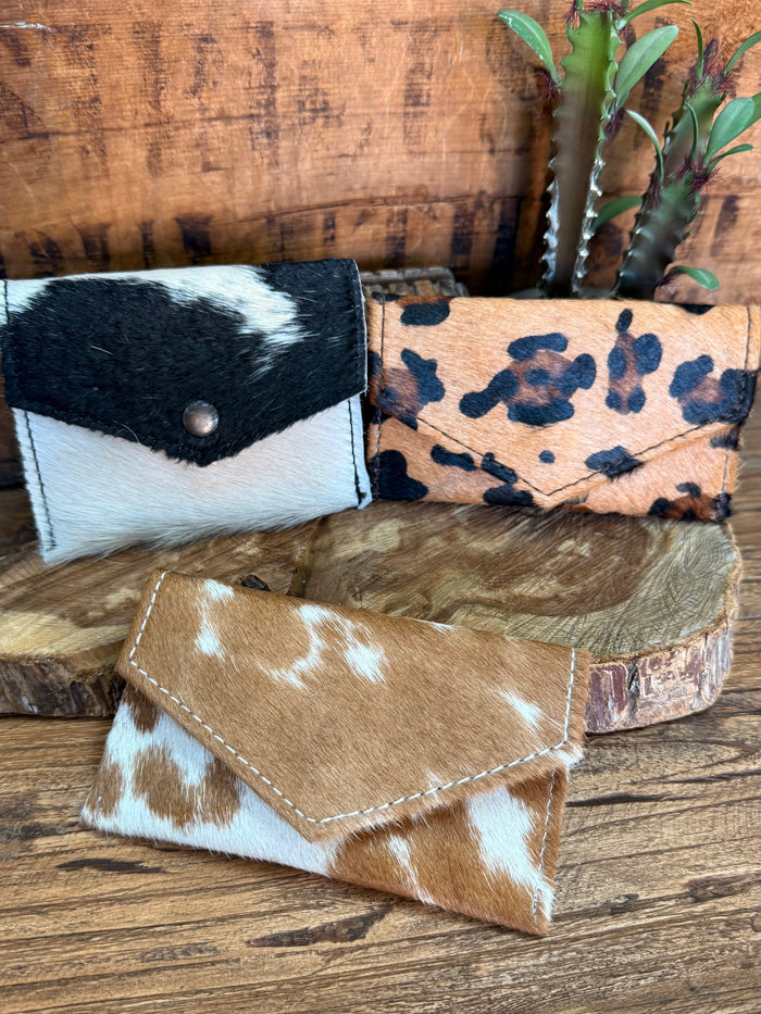 Hair-on envelope wallet set with black/white, leopard, and brown/white hides.