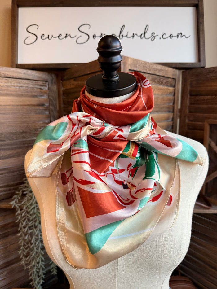 Wild rag scarf, rust-orange with turquoise, green, and white motifs on beige drape