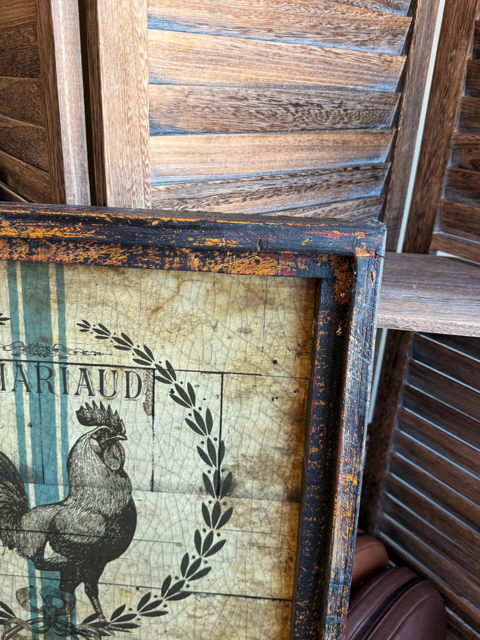 Close-up of rooster print inside distressed blue wooden frame