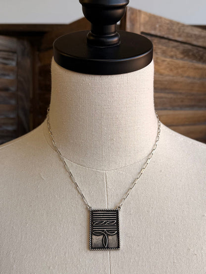 Silver-tone necklace with rectangular boot-stitch pendant and linked chain
