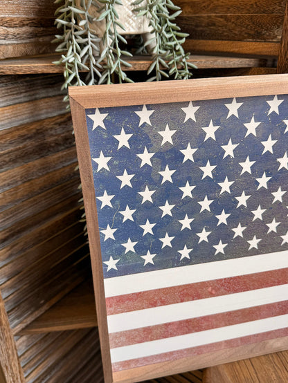 Close-up of framed American flag artwork with blue stars and red-and-white stripes