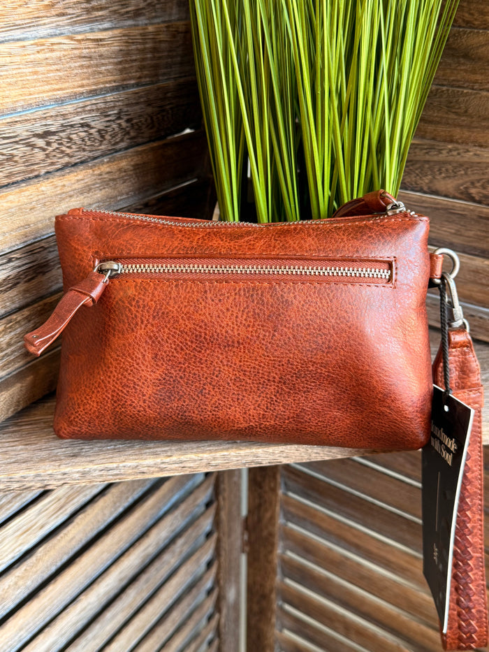 Rusty brown mini wristlet bag with front zip pocket and attached wrist strap
